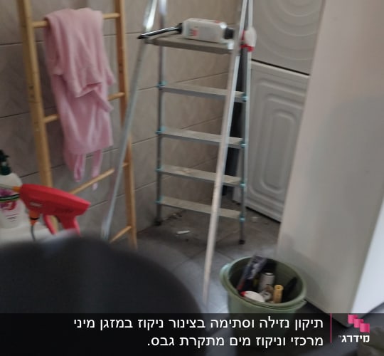סולם מתכת ליד מכונת כביסה בחדר שירות